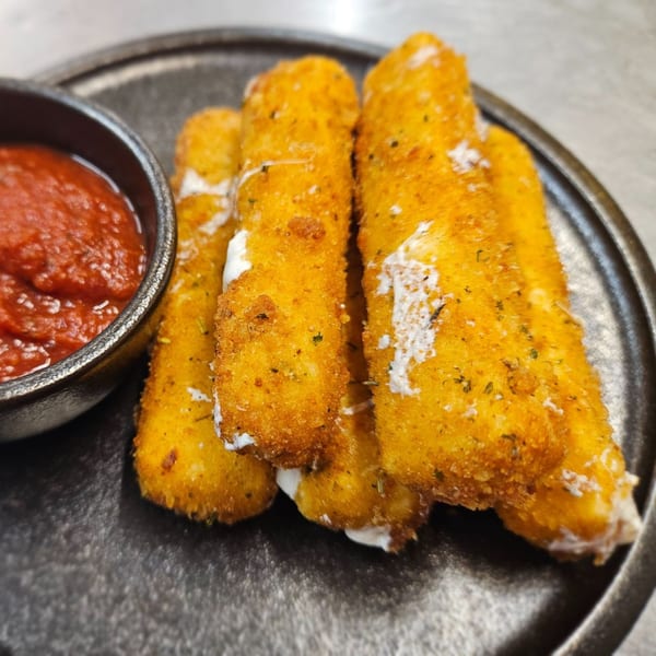 Golden-brown mozzarella sticks with melted cheese oozing out, served with a side of marinara sauce.